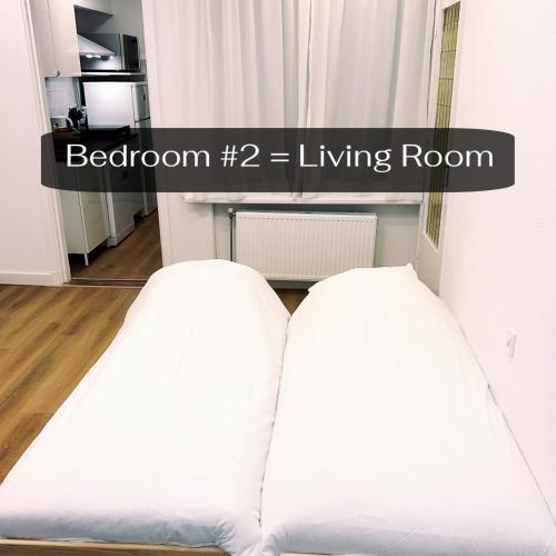 two white beds in a room with the words bedroom living room at DomCity Apt Near Amsterdam Bikes Included One mile to City Centre in Utrecht