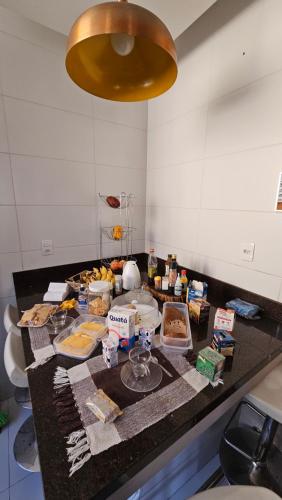 Eine Küchentheke mit einem Haufen Essen drauf. in der Unterkunft Quarto Plutão - banheiro privativo e ar condicionado in Duque de Caxias