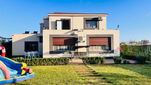 a house with a playground in front of it at Ferme royale Bensliman in O Ben Slimane