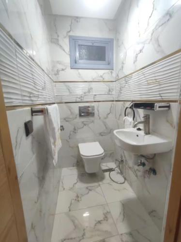 a white bathroom with a sink and a toilet at Ferme royale Bensliman in Ben Slimane