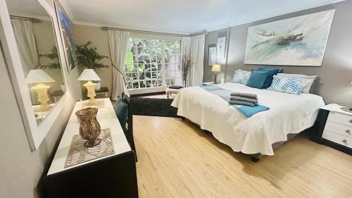 a bedroom with a large bed and a window at Artzys Cottage 1km to Olivedale Clinic in Northriding