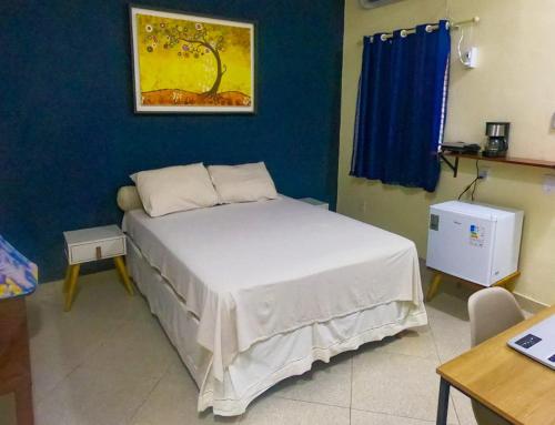 a bedroom with a white bed with a blue wall at Casa Marajoara in Soure