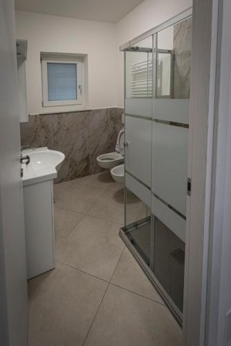a bathroom with a glass shower and a toilet at Residence Malpensa da Andrea in Cardano al Campo