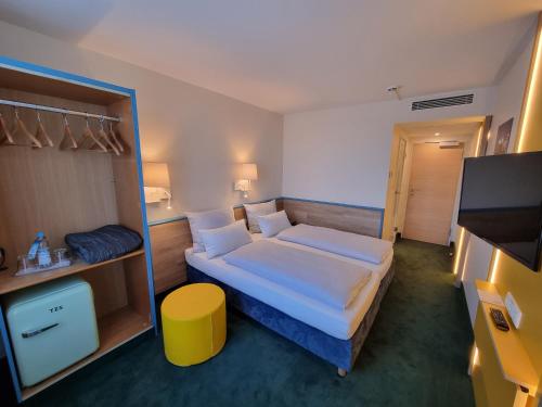a hotel room with a bed and a tv at myMINGA13 - Hotel & serviced Apartments in Munich