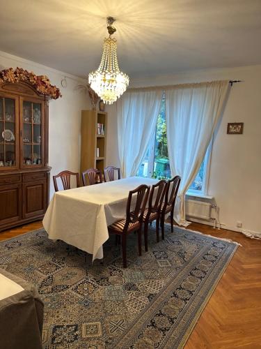 a dining room with a table and chairs and a chandelier at Spacious and charming villa close Gothenburg in Kållered