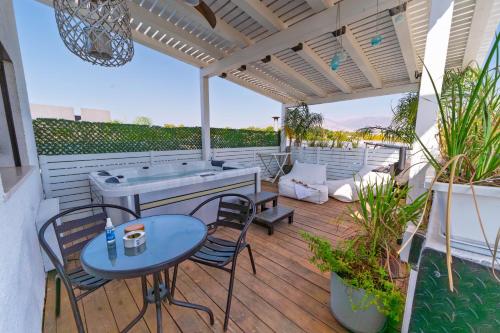 eine Terrasse mit Tisch und Stühlen sowie ein Whirlpool in der Unterkunft LOMA in HaGoshrim