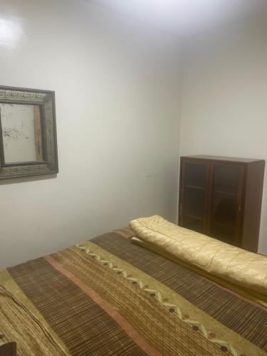 two beds in a room with a picture on the wall at Laziza in Temara