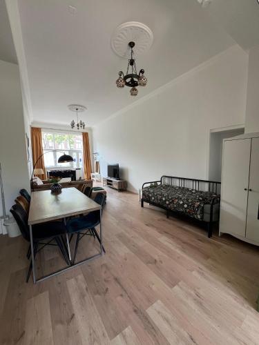 a living room with a bed and a table at Achterom B & B in Delft