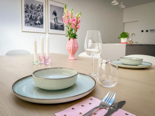 a table with a bowl and plates and glasses on it at Casa Mare Boutique in Blankenberge