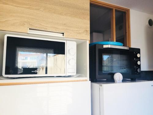 Una cocina o zona de cocina en Le Balcon du Soleil studio climatisé Wifi coin nuit lit douillet proche cure et étang