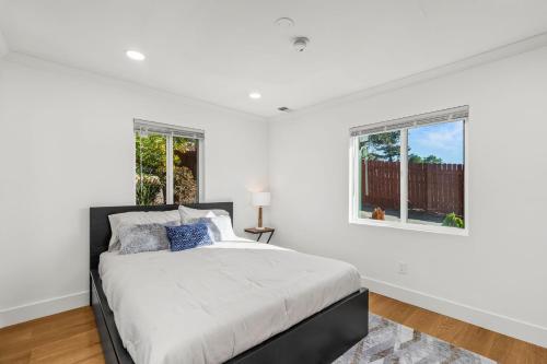 ein weißes Schlafzimmer mit einem Bett und einem Fenster in der Unterkunft Spacious Modern Farmhouse Retreat with Two Kitchens and Pool - Ideal for Large Groups and Families in Rancho Bernardo