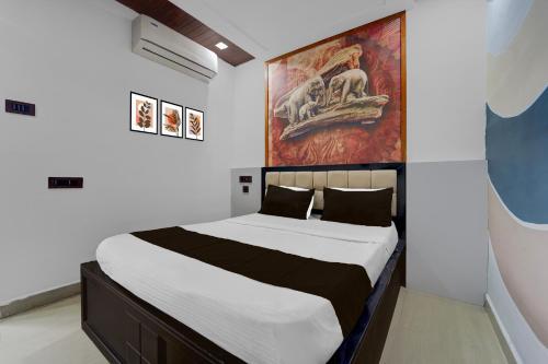 a bedroom with a bed with a painting on the wall at Hotel O The KG Meridian in Ambāsamudram