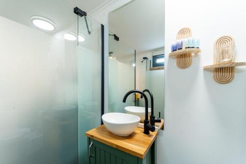 une salle de bains avec lavabo et douche en verre dans l'établissement LOMA, à Hagoshrim