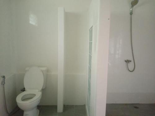 a white bathroom with a toilet and a shower at GELATHAÏ Home in Ko Phayam