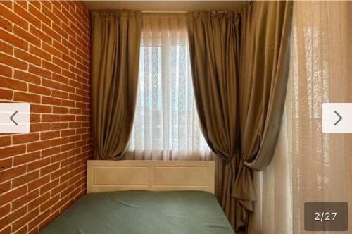 a bedroom with a brick wall and a window at Le bijou-Tomov Plaza in Plovdiv
