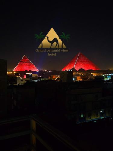 a group of red pyramids with the grand pyramid view hotel at Grand Pyramid View Hotel in Cairo