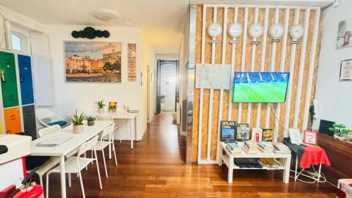 a room with tables and chairs and a wall with clocks at White House Lisbon Hostel in Lisbon