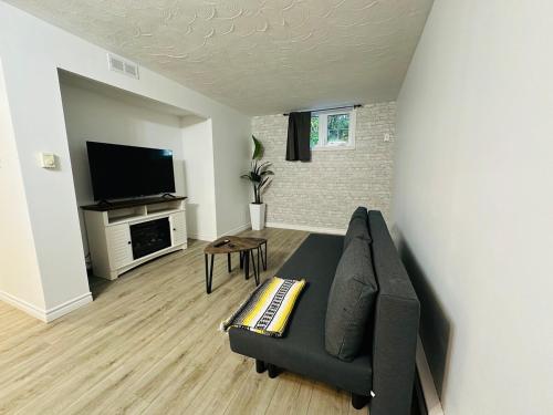 a living room with a couch and a flat screen tv at Oscar's Retreat - 1Bedroom Apart in Moncton