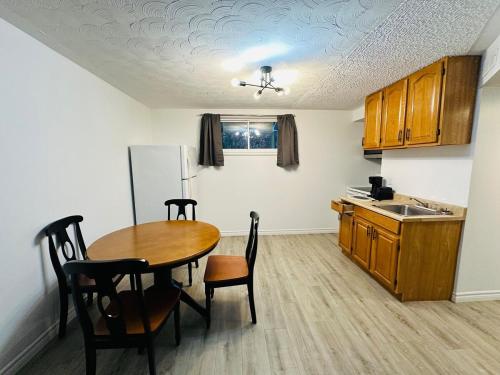 a kitchen with a table and chairs and a refrigerator at Oscar's Retreat - 1Bedroom Apart in Moncton