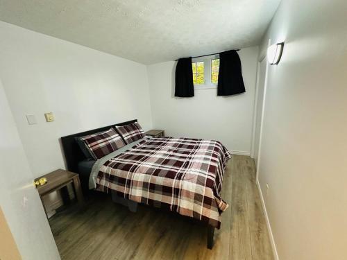 a small bedroom with a bed and a window at Oscar's Retreat - 1Bedroom Apart in Moncton