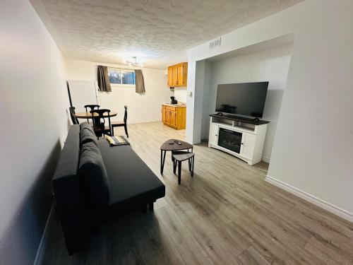 a living room with a couch and a television at Oscar's Retreat - 1Bedroom Apart in Moncton