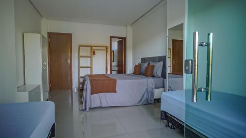 una stanza d'albergo con un letto e uno specchio di Vila Fox Suites com Varanda a Lençóis