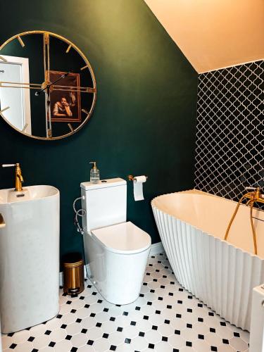 a bathroom with a tub and a toilet and a sink at Willow32 Chalet in Bran
