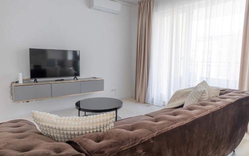 a living room with a large couch and a tv at Joy City Stay Forest 54-85 in Dumbrăviţa