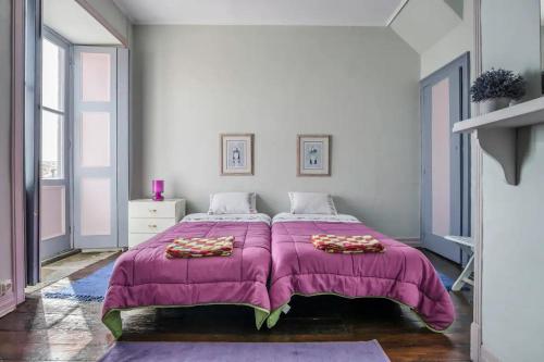 a bedroom with a large bed with a pink blanket at quarto duplo downtown in Ponta Delgada