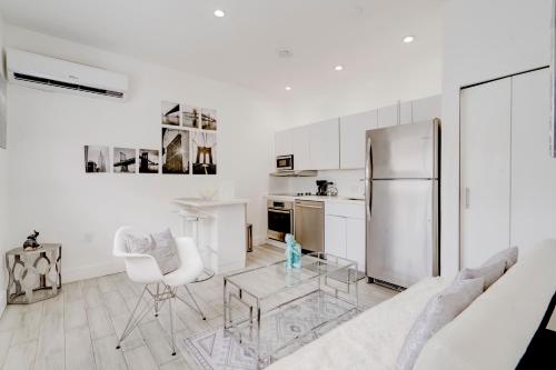 Una sala de estar blanca con un refrigerador de acero inoxidable. en Modern & New,Excellent Location Miami, en Miami