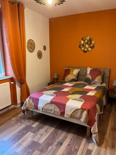 a bedroom with a bed with a colorful comforter at Chez F & G in Sélestat
