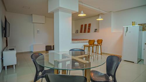una sala da pranzo con tavolo e sedie in vetro di Vila Fox Suites com Varanda a Lençóis