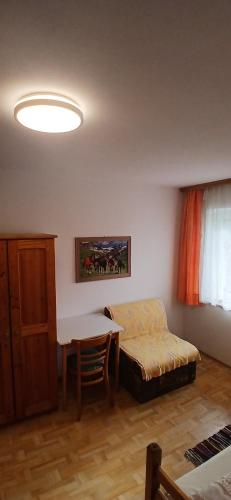 a room with a bed and a desk and a table at Privatzimmer in Wolfern