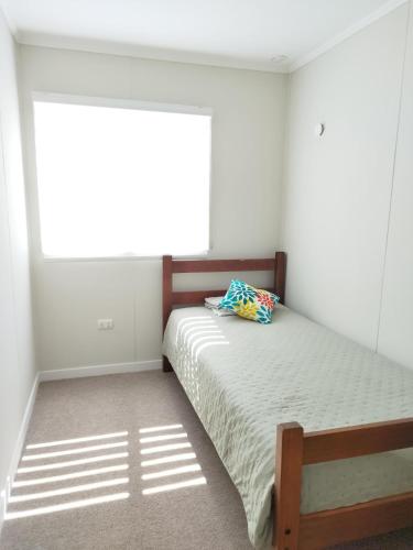 a bedroom with a bed and a window at Cabaña Villarrica Los Carpinteros in Villarrica