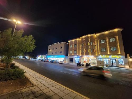 a car driving down a city street at night at شقق الفخامة in Al Madinah