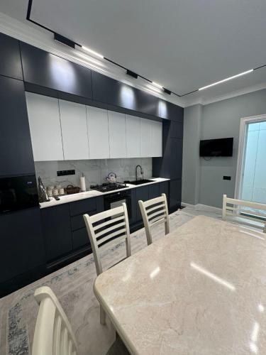 een keuken met een tafel en stoelen in een kamer bij Prime House Samarkand 2 in Samarkand