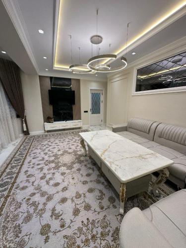 een grote woonkamer met een bank en een tafel bij Prime House Samarkand 2 in Samarkand