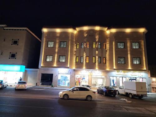 a large building with cars parked in front of it at شقق الفخامة in Al Madinah