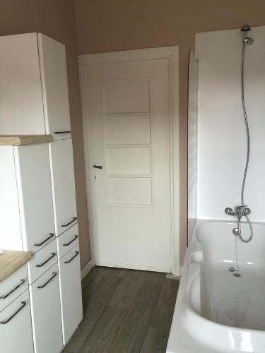 a bathroom with a white sink and a door at Holiday Home near town in Aarschot