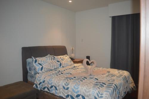 a bedroom with a bed with two swans on it at Tambuli Seaside Living Tower F, Unit J Level 15 in Maribago