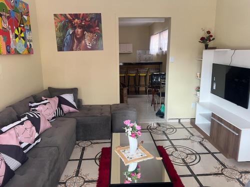 uma sala de estar com um sofá e uma TV de tela plana em Exclusive Seasonal House for COP 30 Luxury for groups of 6 people em Belém