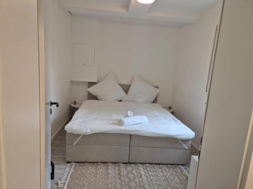 Cama en habitación pequeña con espejo en Hyggeapartment Gailingen - Dein Rückzugsort am Hochrhein, en Gailingen