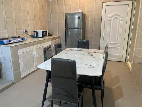 a kitchen with a table and a refrigerator at SLASEL JABAL SHAMS HOUsE in Sa‘ab Banī Khamīs