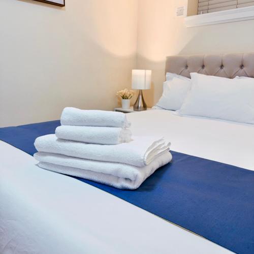 a pile of towels sitting on top of a bed at Near Skytrain Metrotown Private Entry 3min walk to grocery food in Burnaby