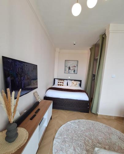 a bedroom with a king sized bed and a table at Reily Luxury Homes - Studio Apartment, Syokimau near JKIA & SGR, PARK VIEW in Nairobi
