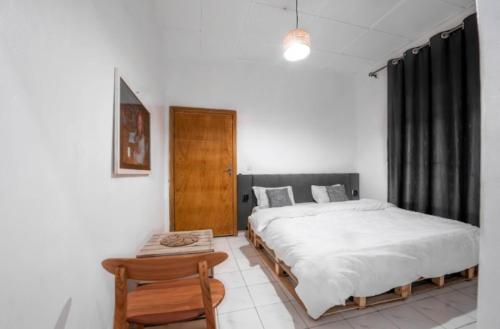 a bedroom with two beds and a table in it at Pili House, Rwanda in Ruhengeri