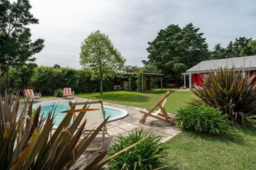 ein Hinterhof mit einem Pool und einer roten Scheune in der Unterkunft Casa de Campo Duggan - San Antonio de Areco in Duggan