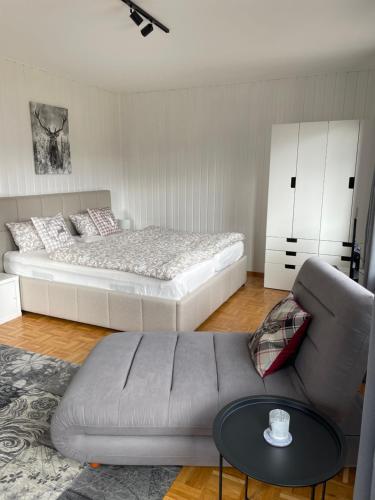 a bedroom with a bed and a couch and a coffee table at Ruhiges Apartment in Weissach - Nähe Porsche in Weissach