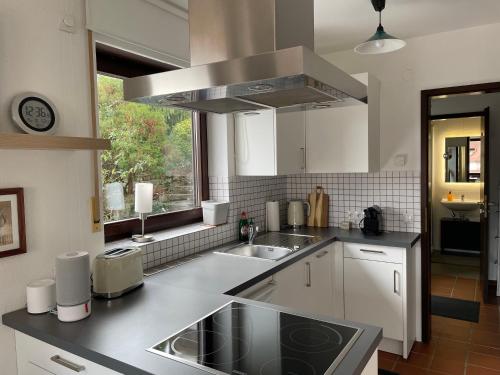 a kitchen with white cabinets and a sink and a window at Ruhiges Apartment in Weissach - Nähe Porsche in Weissach
