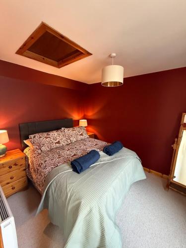 a bedroom with a bed with two blue pillows on it at Friar's Rest - Beauly Village in Beauly